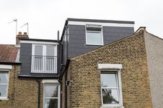 two windows on the side of a brick building