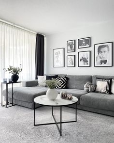 a living room with gray couches and pictures on the wall above them, along with a coffee table