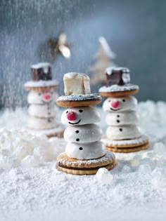 snowmen made out of cookies and marshmallows are sitting in the snow