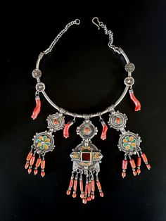 Morocco - Berber necklace silver choker with enamelled plates, red glass bead, genuine coral beads in pendants Technique: Possibility of tightening or loosening the hoop by slight pressure depending on the size of the neck Weight: 188 grams Feel free to contact me for any question about this item, I will be happy to answer you as soon as possible. Visit my Etsy Shop: https://www.etsy.com/fr/shop/TIFINAGH Traditional Red Dangle Necklace, Red Necklaces With Silver Beads For Festival, Red Amulet Necklace With Polished Beads, Red Necklace With Silver Beads For Festival, Red Beaded Amulet Style Jewelry, Red Amulet Necklace With Colorful Beads, Traditional Orange Necklaces With Dangling Beads, Traditional Orange Necklace With Dangling Beads, Silver Amulet Necklace With Colorful Beads