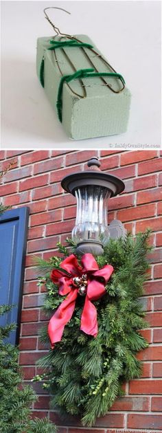 christmas wreath hanging on the side of a brick building with presents tied to it's sides