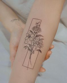 a woman's arm with flowers in a vase tattoo on the left inner forearm