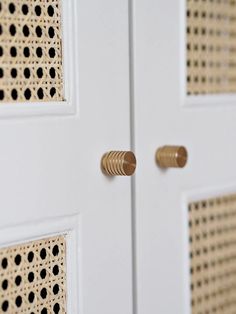 two white doors with gold knobs on each side and black dots on the sides