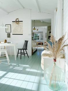 a room with white walls and wooden floors has blue flooring in it, along with two chairs and a table