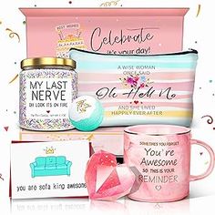 a pink gift box with two mugs, a pillow and some cards