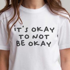 a woman wearing a t - shirt that says it's okay to not be okay