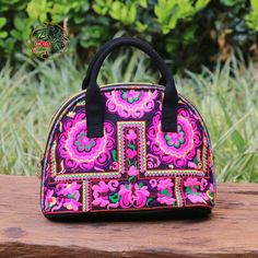 a colorful handbag sitting on top of a wooden bench