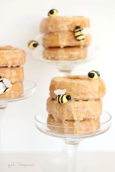 donuts with honeybees on them are sitting in glass dishes and placed on top of each other