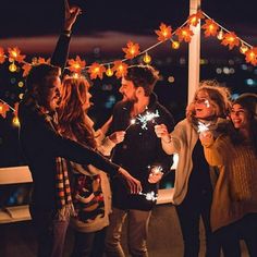 a group of people standing around each other holding sparklers