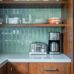 a kitchen with wooden cabinets and white counter tops next to a silver toaster oven