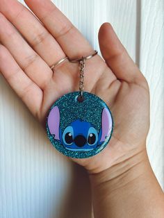 a hand holding a keychain with an image of stitching stitch on it