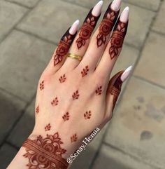 a woman's hand with henna tattoos on it