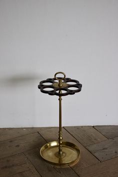 a brass candle holder on a wooden floor