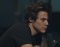 a young man sitting in front of a laptop computer