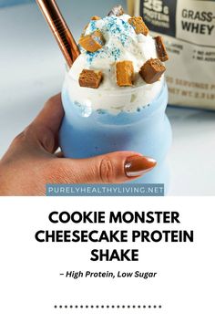 cookie monster cheesecake protein shake in a blue glass with cinnamon sticks sticking out of it