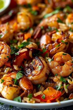 a close up of a plate of shrimp and rice with garnished cilantro