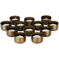 twelve brass tealight candles with white votives in the middle, on a white background