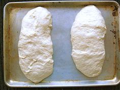 two uncooked pieces of bread on a baking sheet