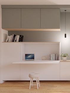 a white desk with a laptop on top of it next to a bookshelf