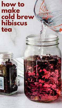 a glass jar filled with liquid next to a cup full of tea