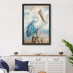 a painting of a pelican sitting on top of a piece of wood in a living room