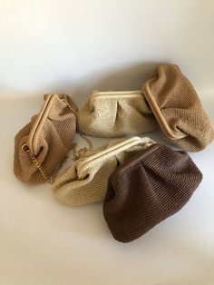 three purses sitting on top of a white table next to each other and one is empty