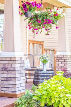 flowers are hanging from the roof of a house