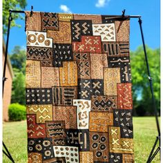 a quilt hanging on a stand in the grass