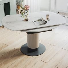 a table with a magazine and flowers on it in the middle of a living room