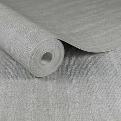 a roll of gray fabric on top of a bed sheet that has been rolled up