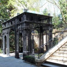 a gazebo sitting on top of a sidewalk next to stairs