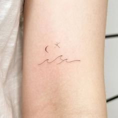 a woman's arm with a small wave tattoo on the left side of her body