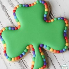 a decorated shamrock cookie sitting on top of a white table