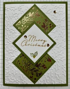 a green and white christmas card with gold foil