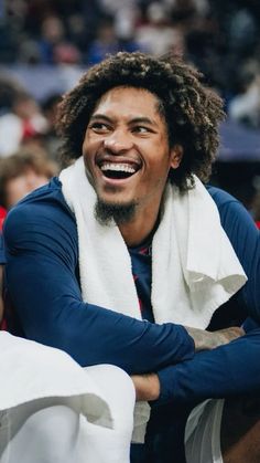 a close up of a person with a towel around his neck and smiling at the camera