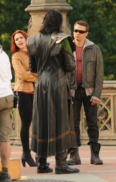 three people standing in front of a statue