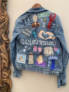 a denim jacket with patches on it hanging from a wall