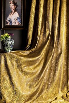 an image of a woman's face on a gold cloth next to a potted plant