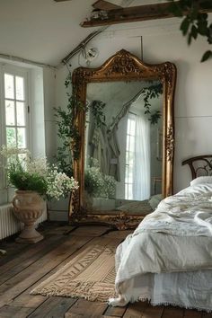 a bed sitting under a large mirror on top of a wooden floor next to a window