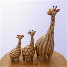 three giraffes and one zebra on a wooden table