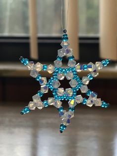 a snowflake ornament hanging from a string