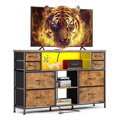 the television is on and there is a tiger painting in front of it that's mounted above an entertainment center