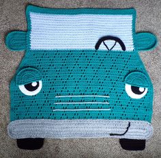 a crocheted car rug with eyes on it