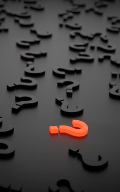 an orange neon sign sitting on top of a black surface with letters all over it