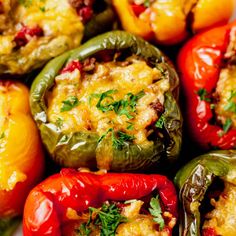 several stuffed peppers with cheese and herbs on the top one is red, yellow and green