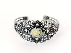 "Two Sisters Cameo Bracelet/Victorian Cameo Bracelet/Cameo/Victorian Cameo Jewelry/Sisters Cameo/Silver Cameo Cuff Bracelet/Wedding Jewelry Victorian Cameo Cuff Bracelet featuring two sisters 25 x 18 mm cameo on a black background set in an antiqued pewter filigree cuff bracelet. Also available in blue. Beautifully detailed antiqued pewter finished brass cuff adjusts to comfortably fit a wrist between 5.75 and 7.75 inches. This is a popular gift for sisters and best friends. Brides - Please conv Victorian Bangle As Gift, Victorian Cuff Bracelet For Wedding, Victorian Antique Silver Bracelets For Wedding, Antique Adjustable Cuff Bracelet For Wedding, Silver Cameo Bracelet For Gifts, Elegant Silver Bracelet With Cameo, Vintage Silver Cameo Bracelet, Vintage Antique Silver Cuff Bracelet, Ornate Antique Silver Cuff Bracelet For Weddings