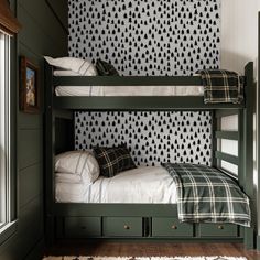 two bunk beds in a room with black and white wallpaper