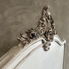 an ornate white bed frame with flowers on it