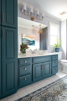 a bathroom with blue cabinets and a white toilet