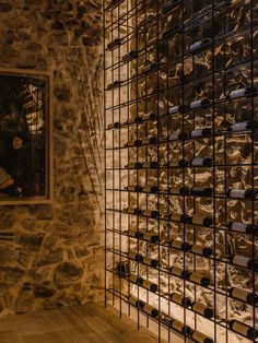 a stone wall with wine bottles on it and a window in the backround